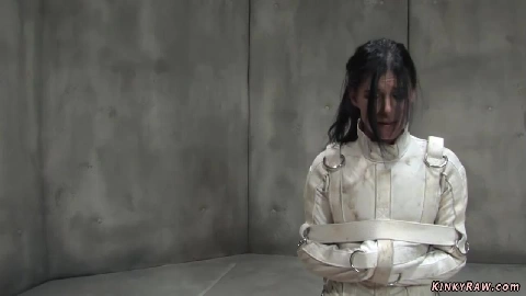 Tanned brunette bound in straitjacket